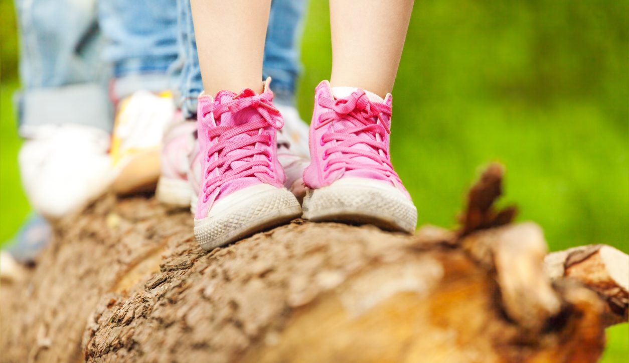 Children's feet in pink sneakers standing on a log child support agreement